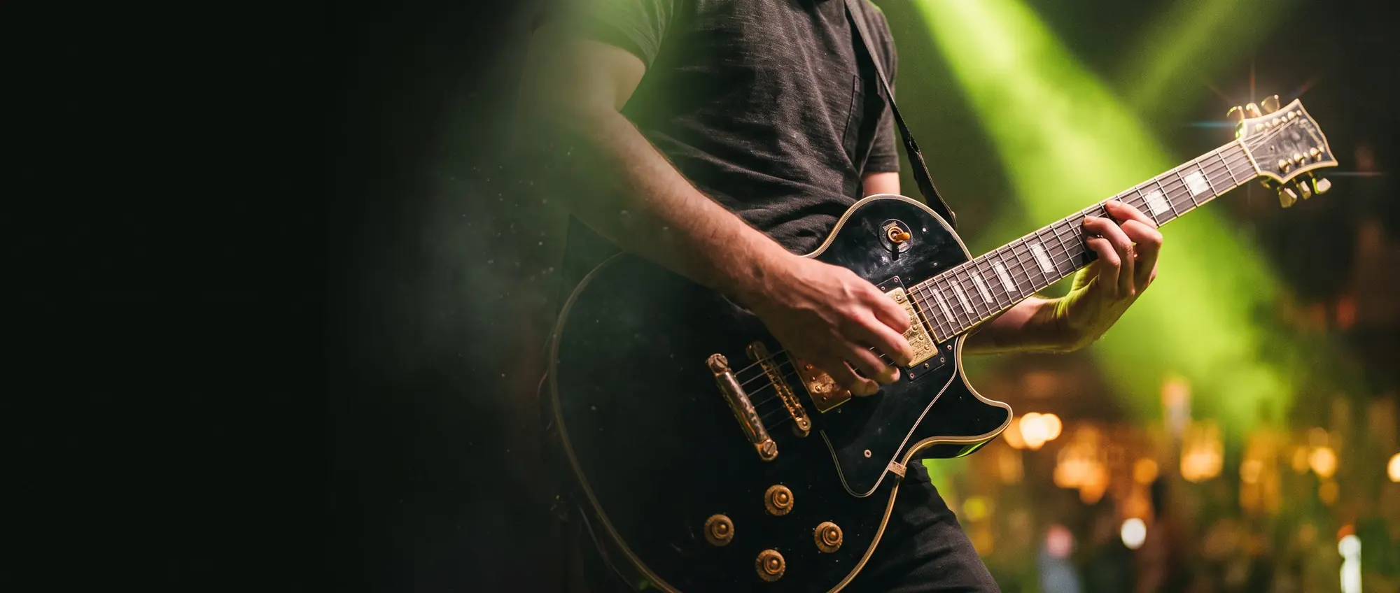 Guitarrista tocando guitarra elétrica no palco com luzes verdes